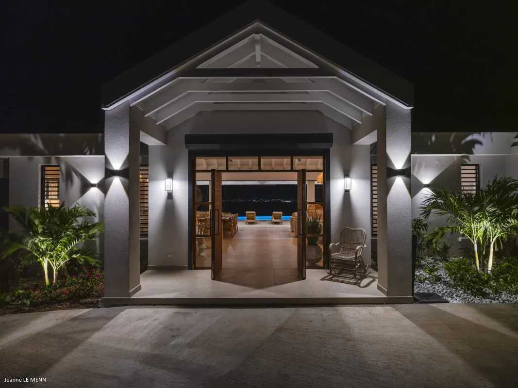 Villa Abaca: Illuminated villa entrance at night looking through open double doors toward the terrace
