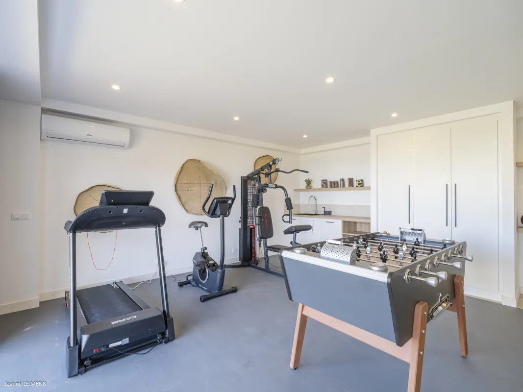 Villa Abaca: Fitness room with a treadmill, stationary bike, weight machine, and foosball table
