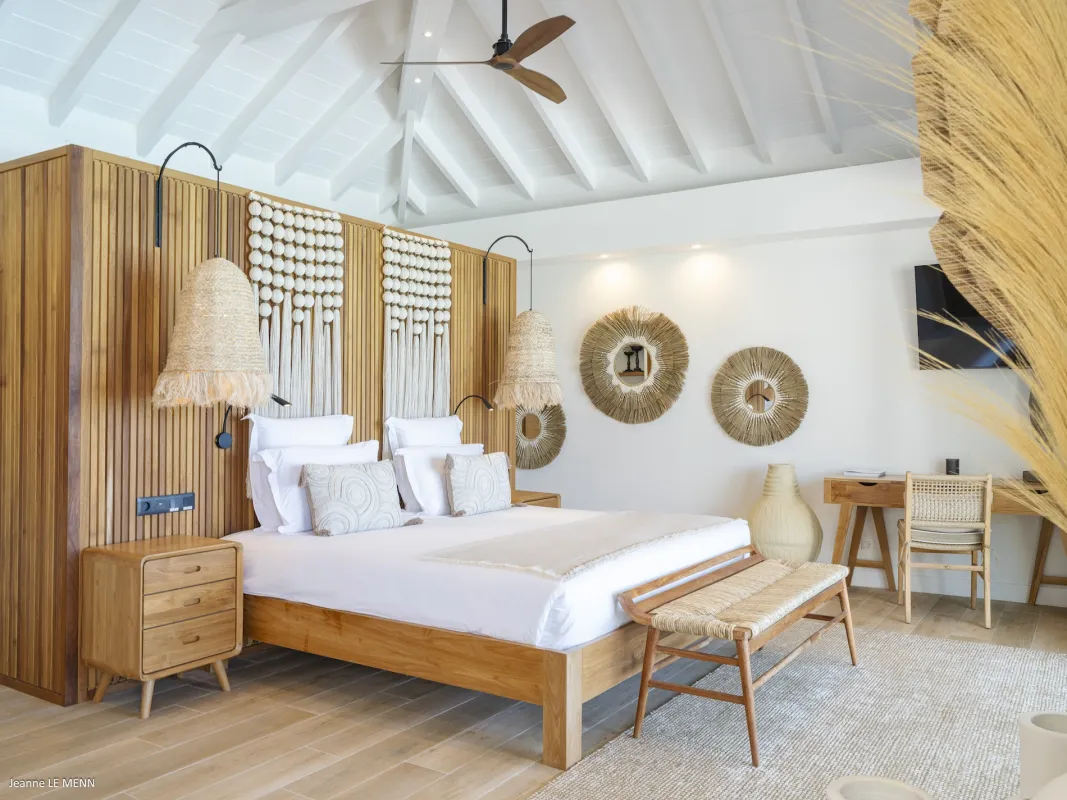 Villa Abaca: Bright bedroom with wooden bed, woven pendant lamps, vaulted ceiling, and study desk