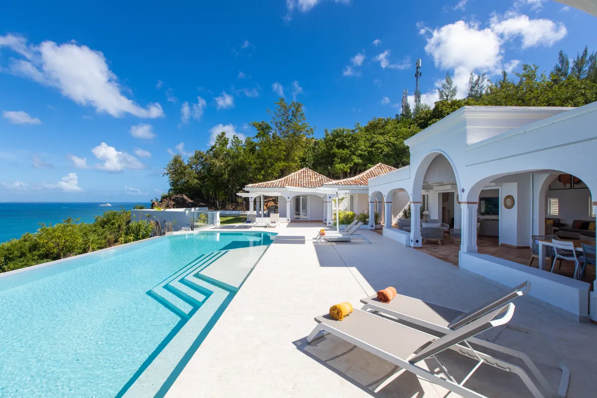 Villa Agama: Infinity pool and sun terrace overlooking the ocean beside a white villa