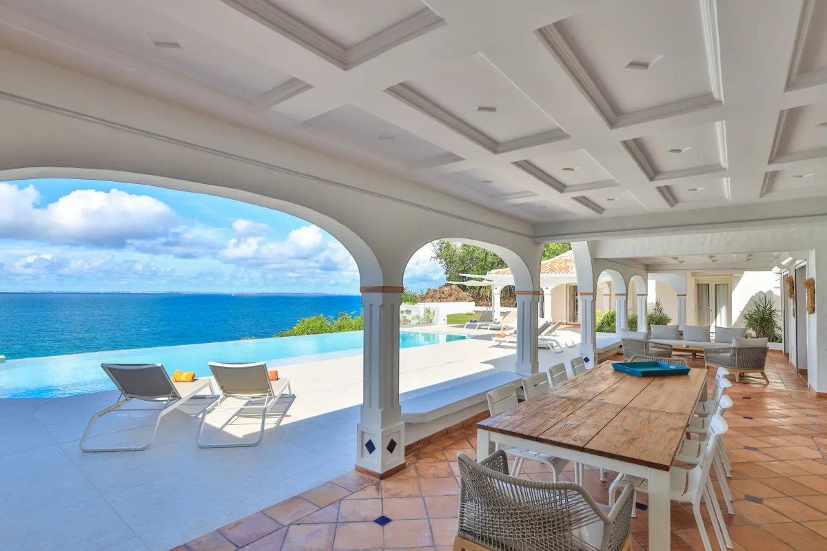 Villa Agama: Covered terrace with dining table overlooking an infinity pool and the ocean