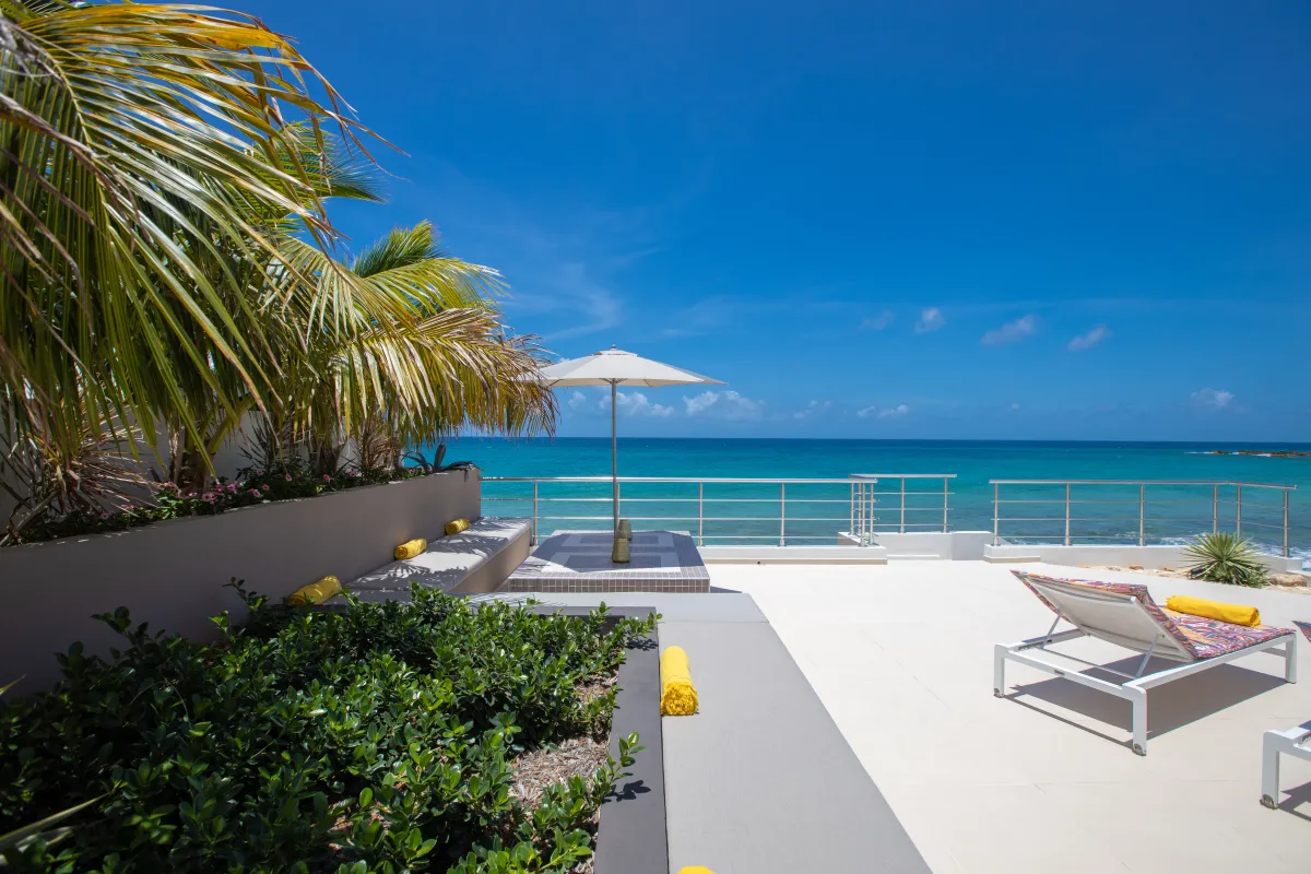 Villa Alma: Sun terrace with lounge chairs and umbrella overlooking the turquoise sea