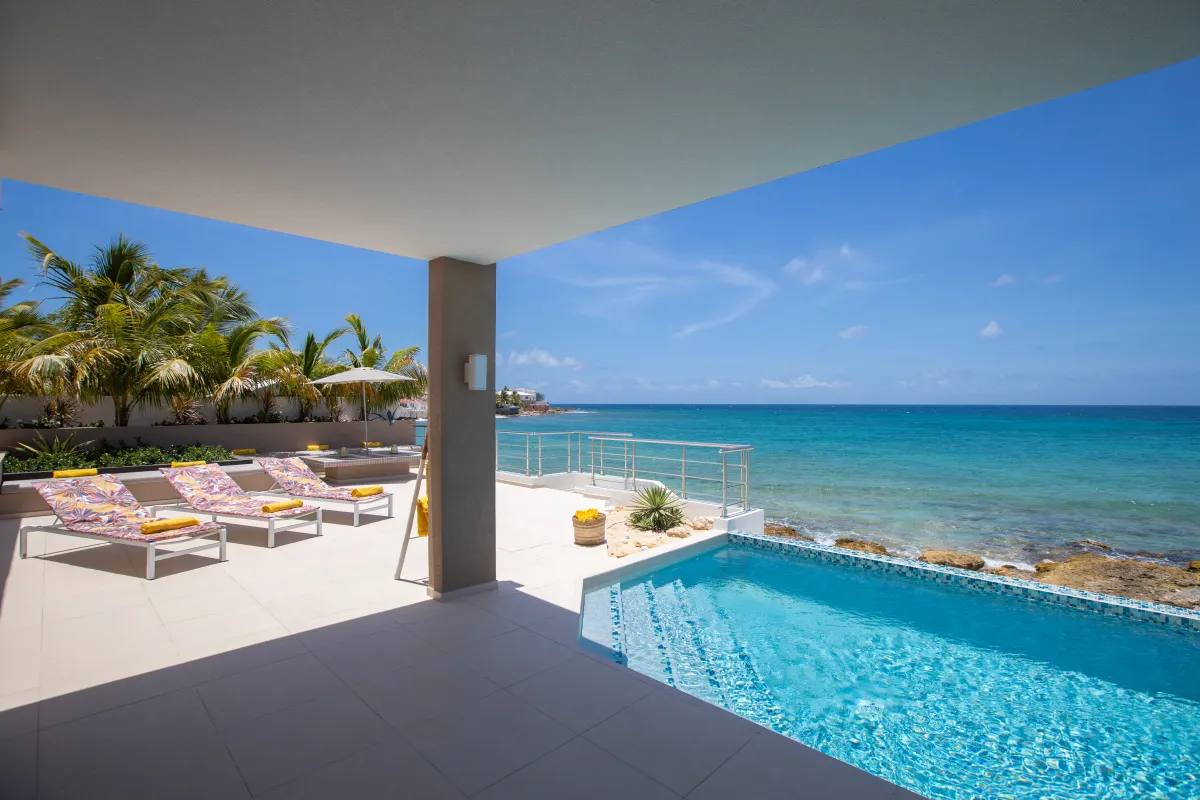 Villa Alma: Covered patio and pool terrace with sun loungers overlooking the turquoise ocean