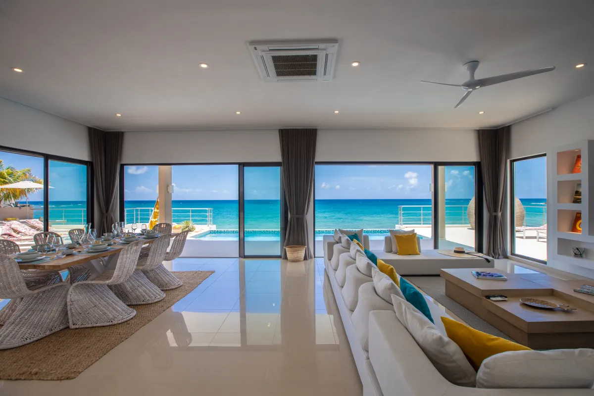 Villa Alma: Open-plan living and dining room with sliding glass doors facing the ocean and pool