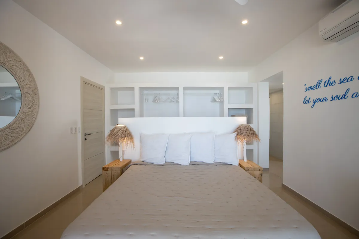 Villa Alma: Bedroom with a king bed, open closet shelving, and woven bedside lamps