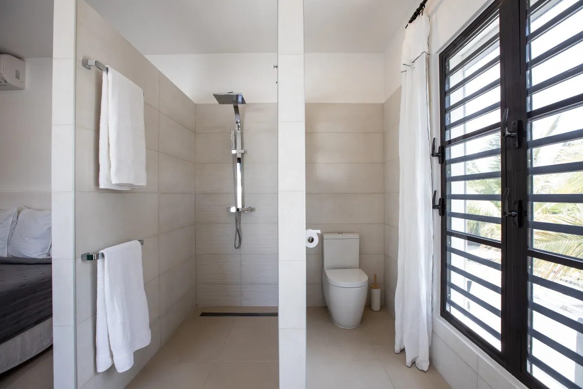 Villa Alma: Modern bathroom with walk-in shower, toilet, and louvered window