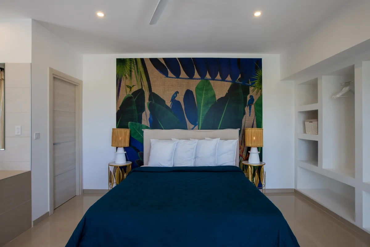 Villa Alma: Bedroom with a king bed, colorful tropical mural, and built-in open closet shelving