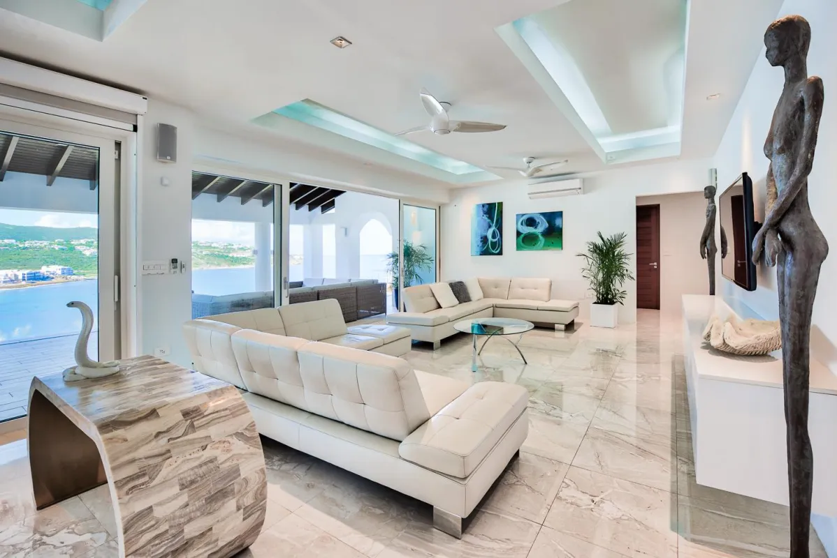 Villa Amalia: Contemporary living room with white leather seating, polished tile floors, and ocean views