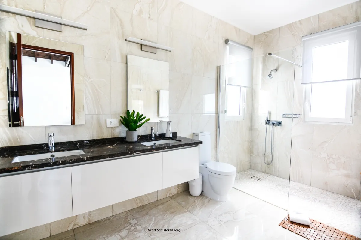 Villa Amalia: Modern bathroom with a double sink vanity, marble-patterned tiles, and a walk-in shower