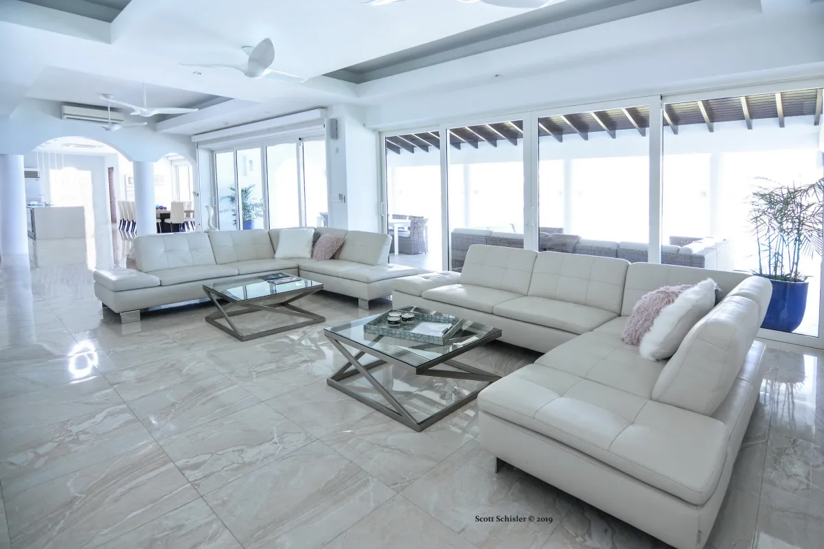 Villa Amalia: Spacious living room with white leather sectional sofas and large glass sliding doors