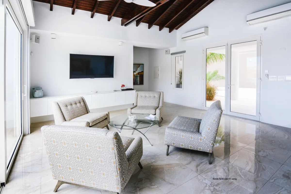 Villa Amalia: Living room with armchairs around a glass coffee table and a wall-mounted television