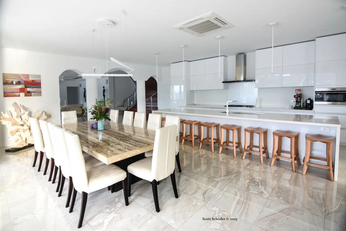 Villa Amalia: Dining area with a large stone table beside a modern open-plan kitchen island