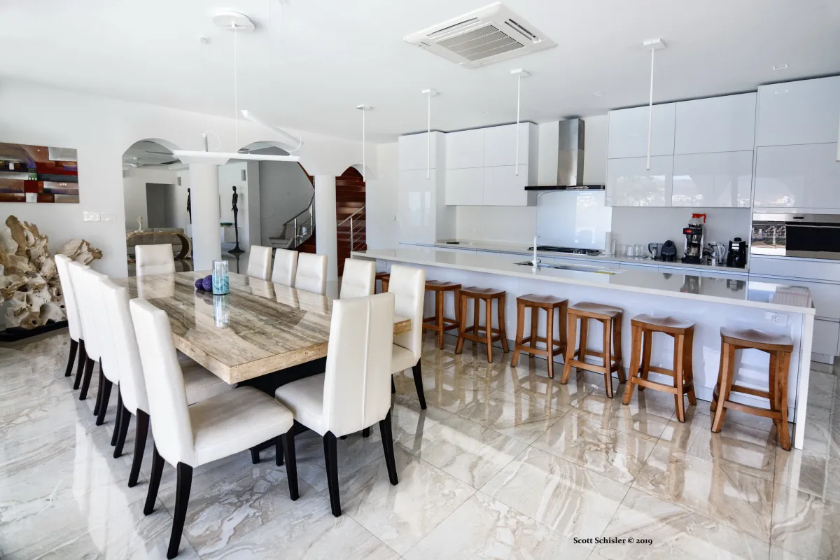 Villa Amalia: Dining table and chairs next to an open kitchen with island and wooden bar stools