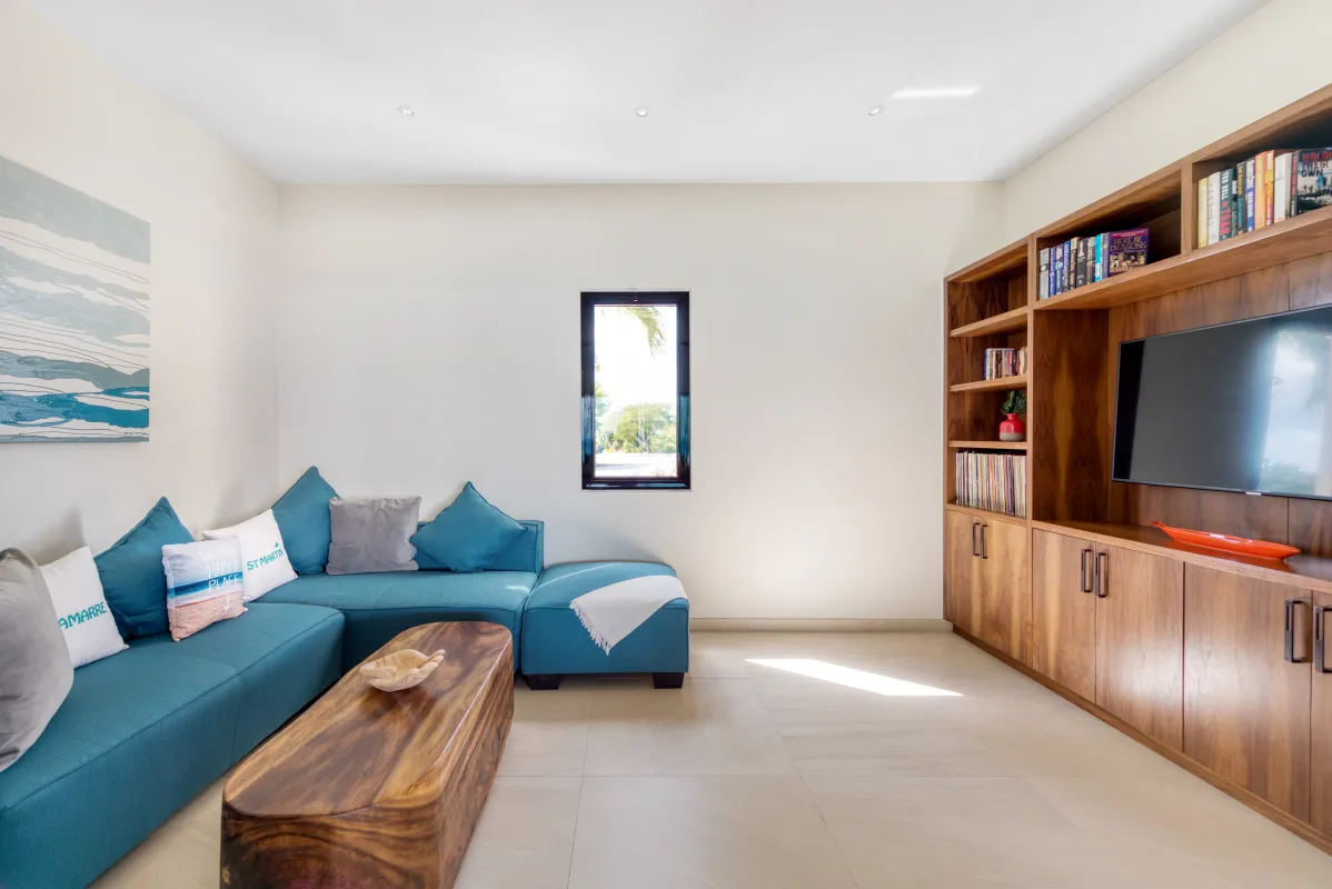 Villa Amandara: Media room with a blue sectional sofa, wooden coffee table, and built-in television console