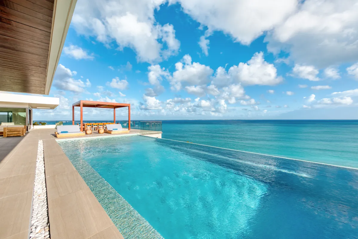 Villa Amandara: Infinity pool overlooking the turquoise ocean with sun loungers and a shaded pergola