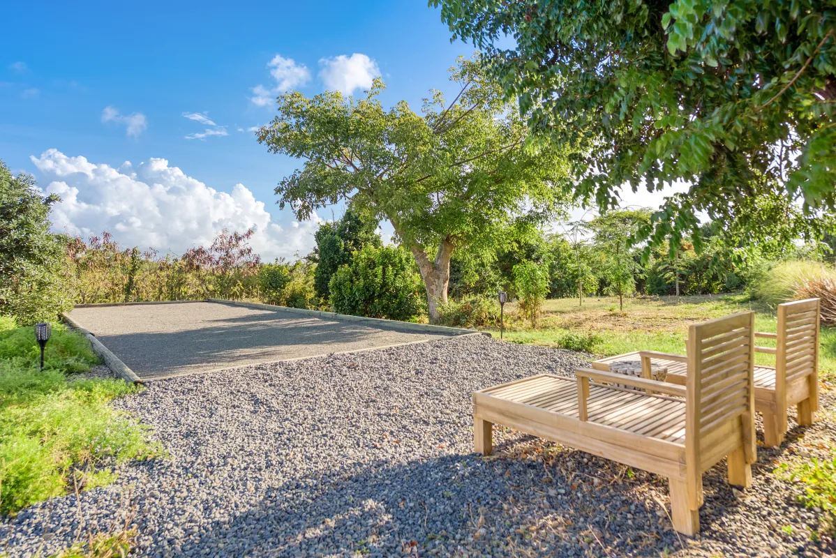 Villa Amandara: Bocce court and wooden lounge chairs in a grassy garden surrounded by trees