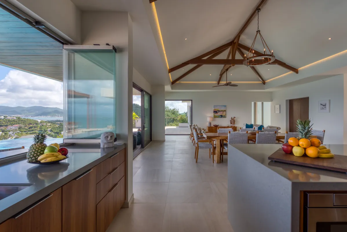 Villa Amandara: Open-concept kitchen and dining area with vaulted wood ceiling and coastal views