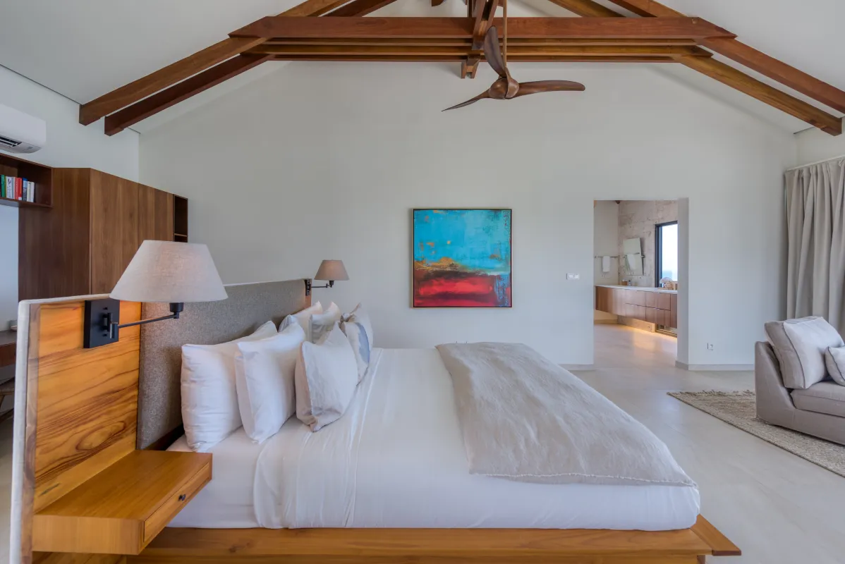 Villa Amandara: Bedroom with a wood platform bed, vaulted wood ceiling, and colorful wall art