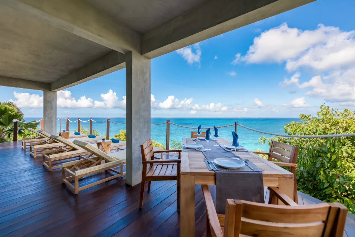 Villa Amandara: Covered wooden terrace with an outdoor dining table and sun loungers facing the sea