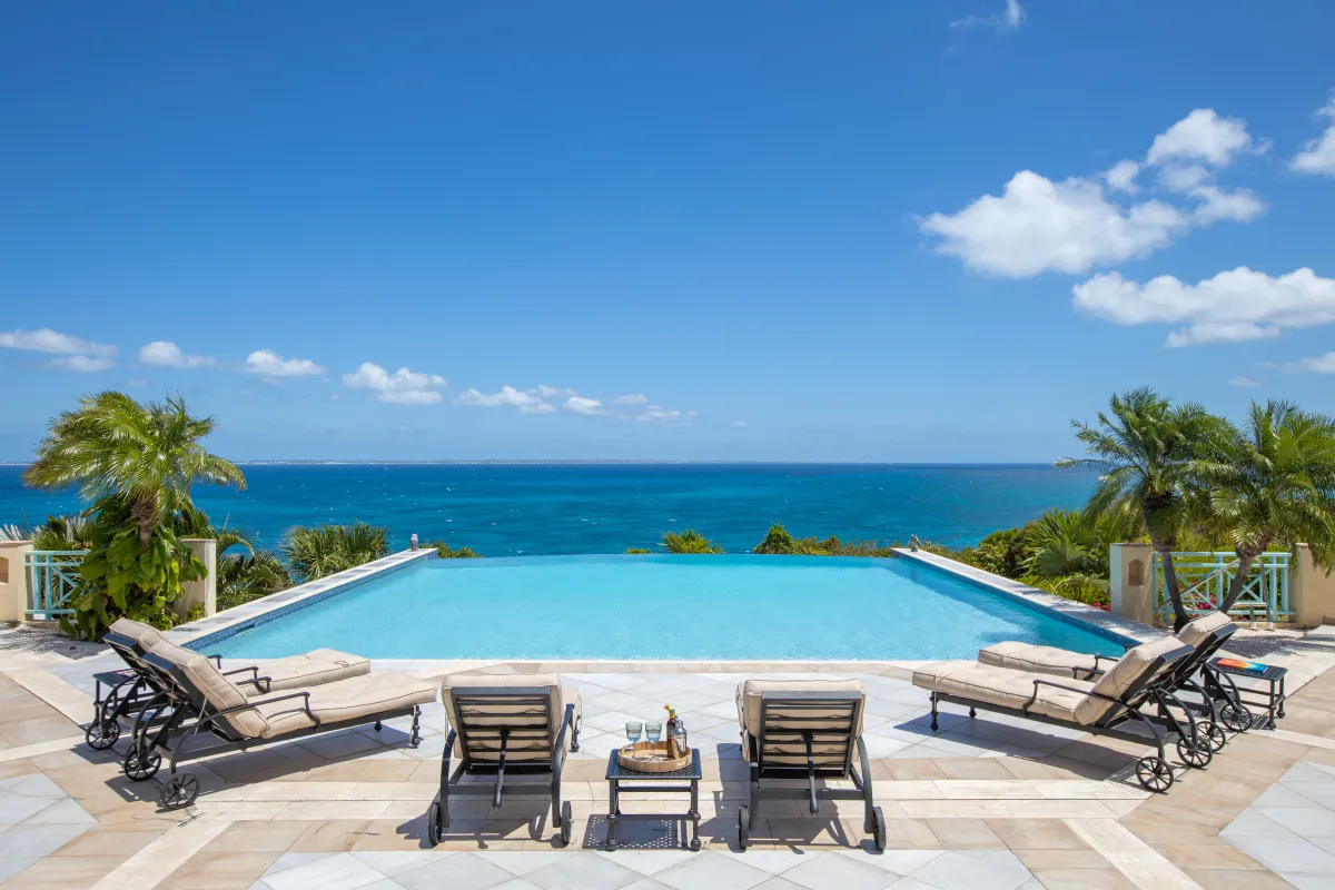Villa Amber: Infinity swimming pool with sun loungers overlooking the open ocean under a blue sky