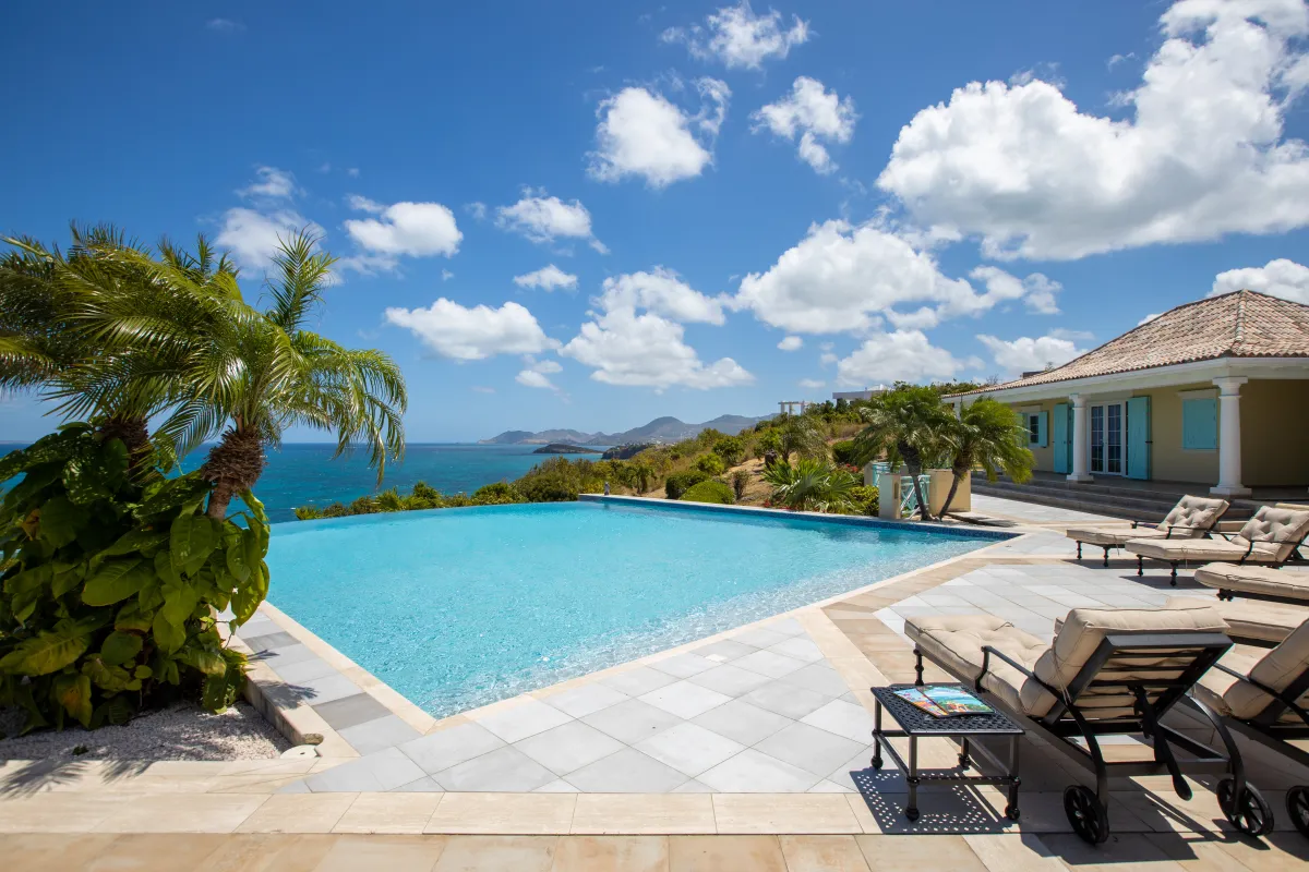 Villa Amber: Infinity swimming pool and lounge chairs on a sunny terrace overlooking the sea