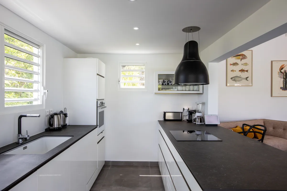 Villa Angelsmart: Modern kitchen with dark countertops, white cabinetry, and an island cooktop