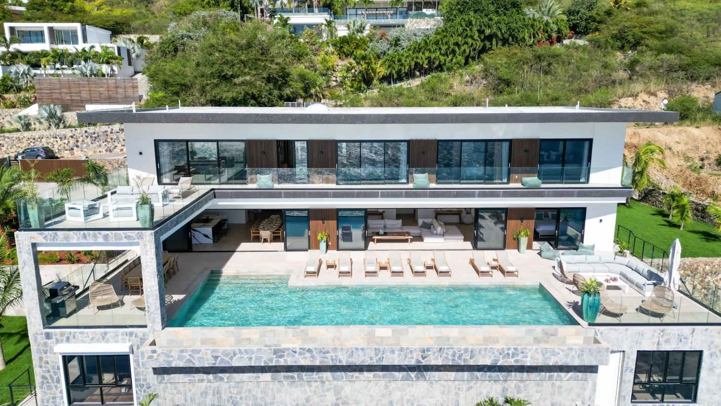 Villa Aqua Dream: Exterior view of a modern hillside villa with an infinity swimming pool and sun loungers