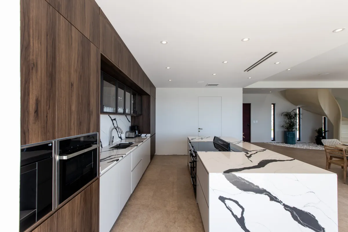 Villa Aqua Dream: Modern kitchen with white and black marble island and warm wood cabinets