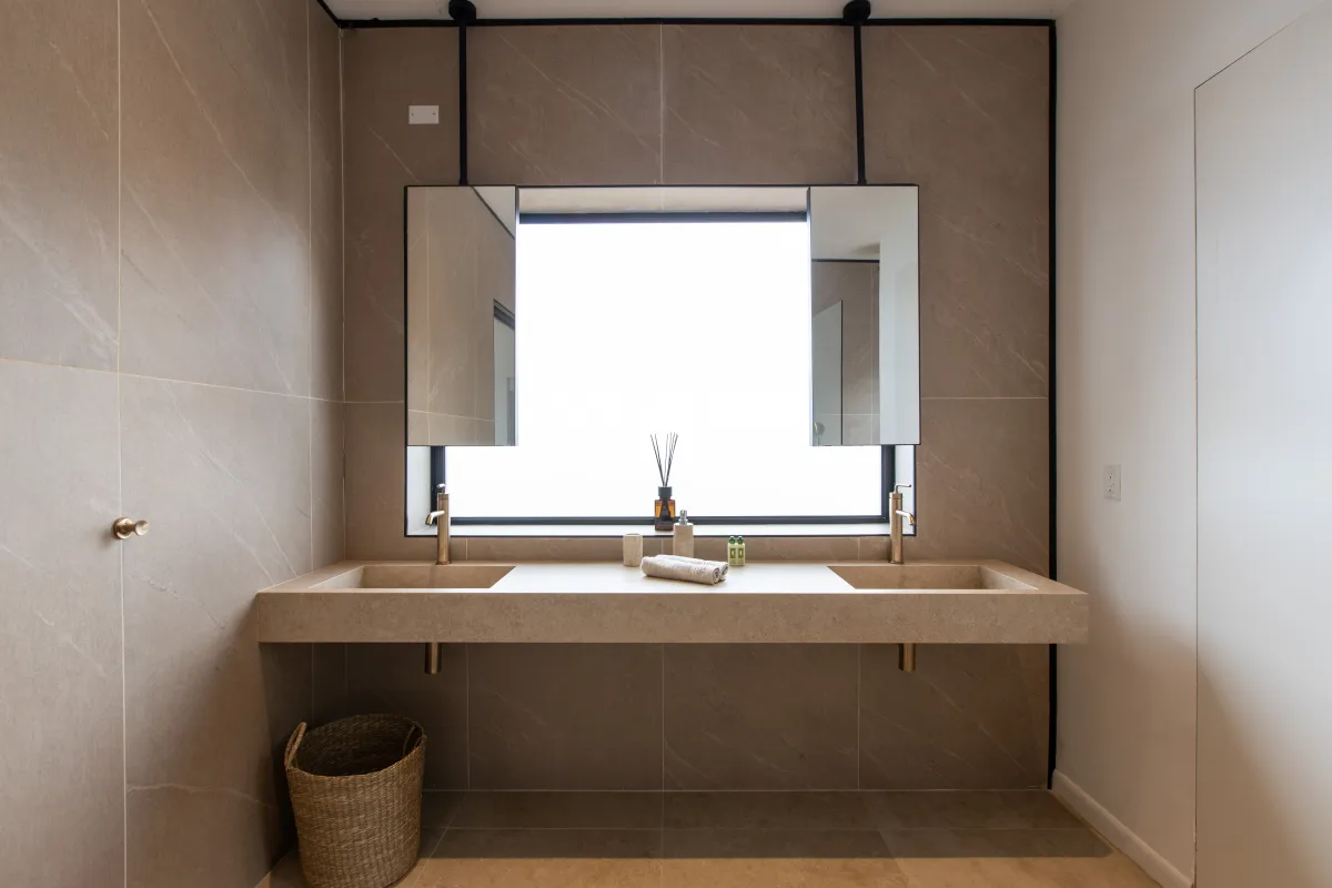 Villa Aqua Dream: Modern bathroom floating double vanity with beige stone sinks and hanging mirrors