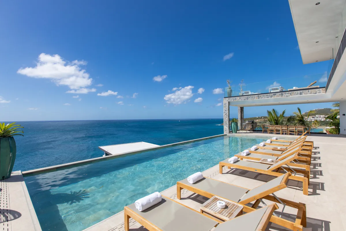 Villa Aqua Dream: Infinity pool with sun loungers overlooking the ocean on a sunny terrace