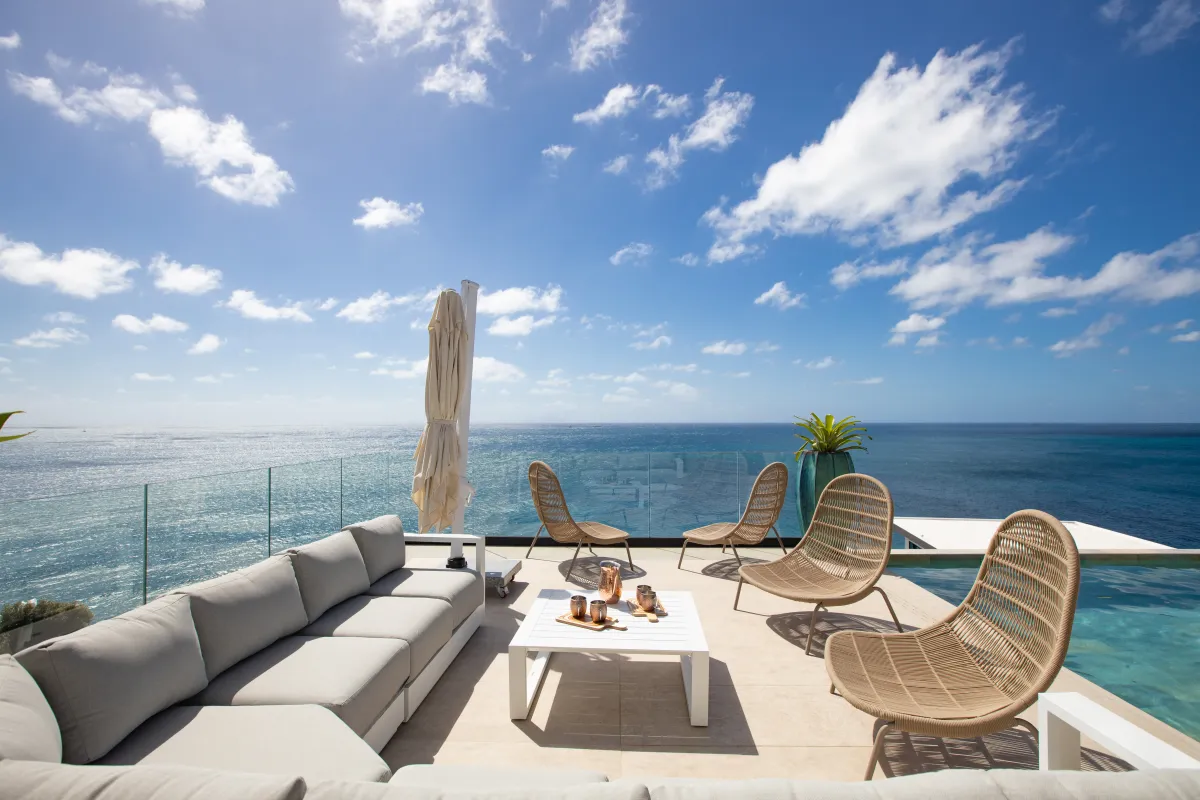 Villa Aqua Dream: Outdoor terrace lounge with sofa and wicker chairs overlooking the ocean