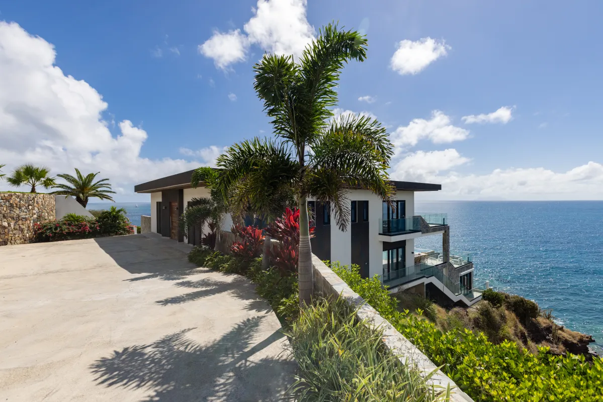 Villa Aqua Vista: Modern cliffside villa exterior and driveway overlooking the blue ocean