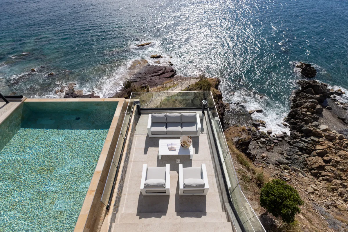 Villa Aqua Vista: Outdoor lounge terrace next to an infinity pool overlooking the rocky coastline and sea