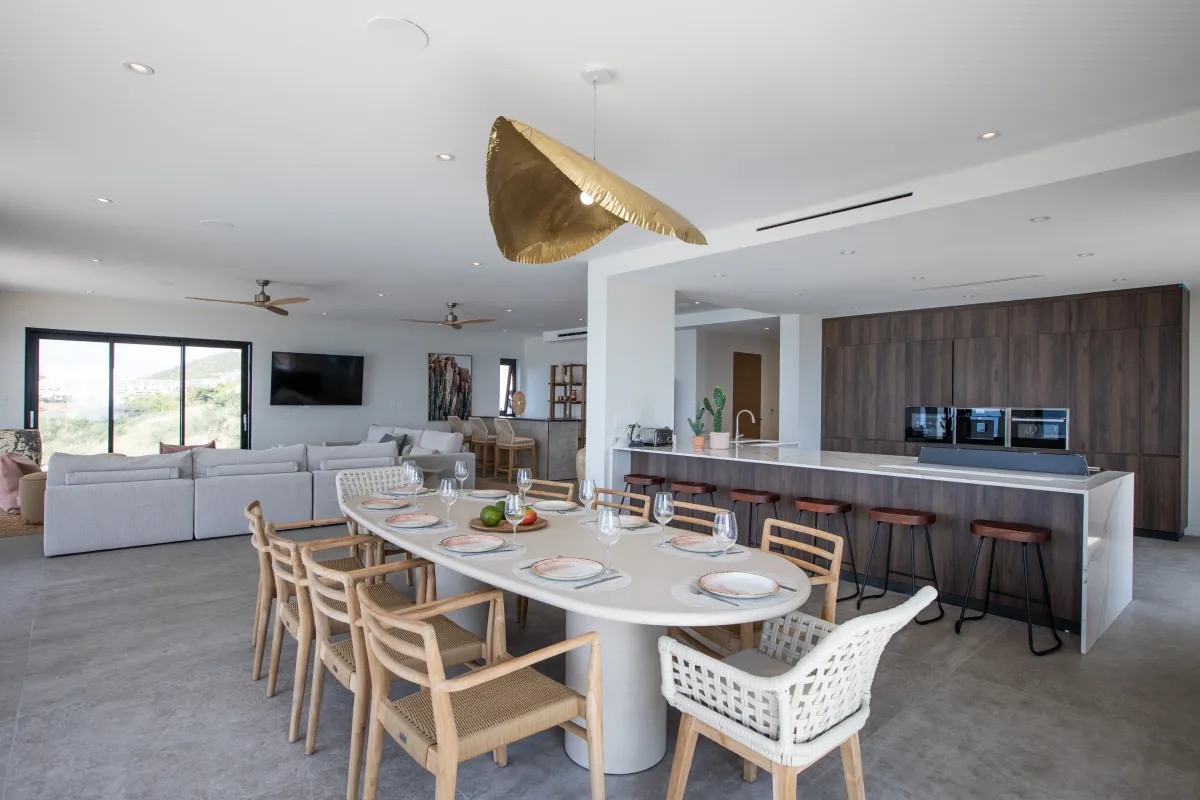 Villa Aqua Vista: Open-concept dining area with an oval table, kitchen island, and adjacent living space