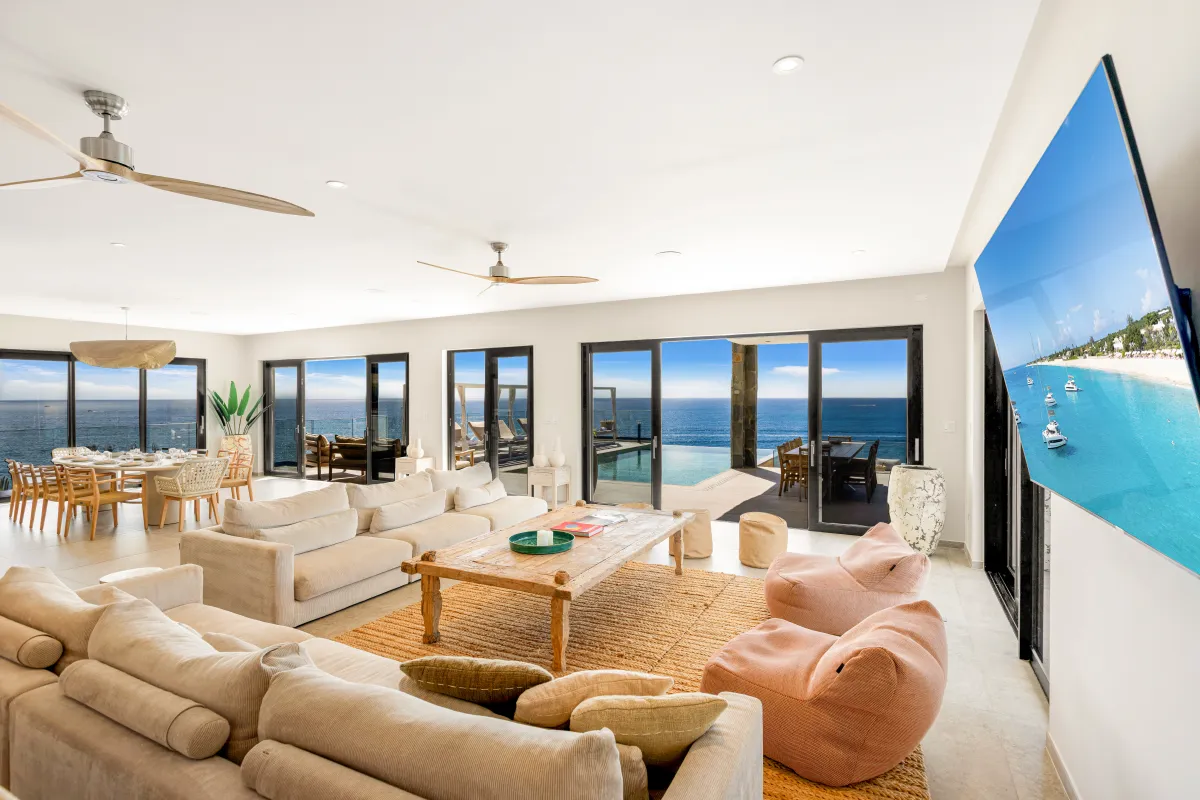 Villa Aqua Vista: Open-plan living room with comfortable sofas and sliding glass doors facing the ocean