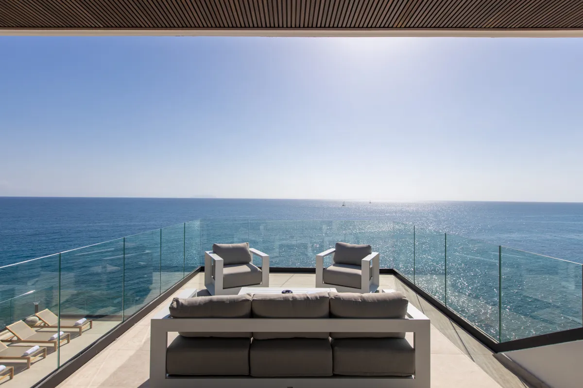 Villa Aqua Vista: Outdoor terrace with modern lounge seating and glass railing overlooking the open ocean