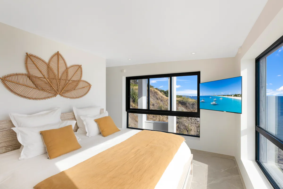 Villa Aqua Vista: Bright bedroom with a king bed, leaf wall art, and large windows with ocean view