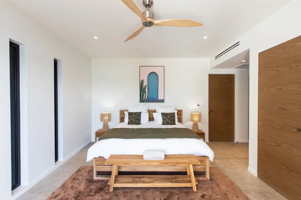 Villa Aqua Vista: Modern bedroom with wooden bed, bedside tables with lamps, and wooden ceiling fan