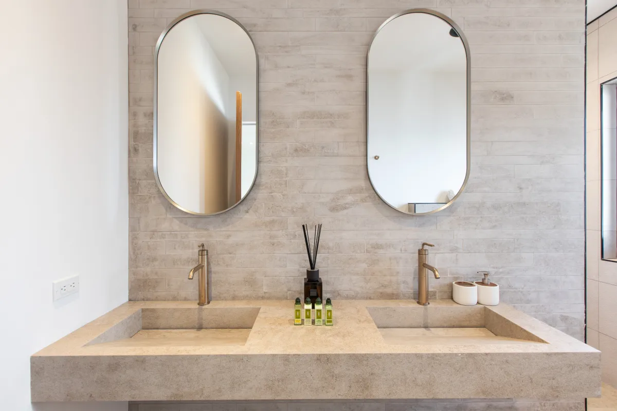 Villa Aqua Vista: Modern bathroom double vanity with stone sinks and pill-shaped mirrors
