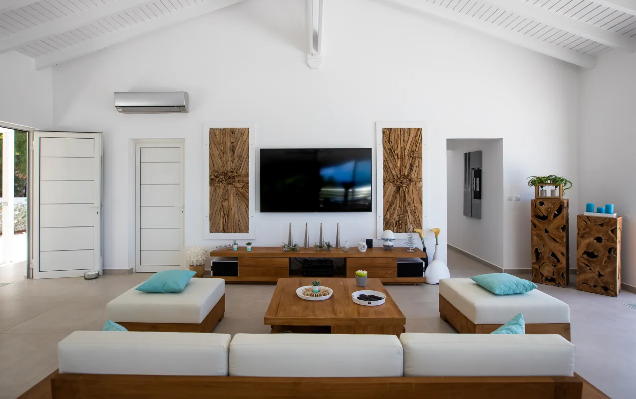 Villa Azur Dream: Living room with white vaulted ceiling, wall-mounted television, and wood accents
