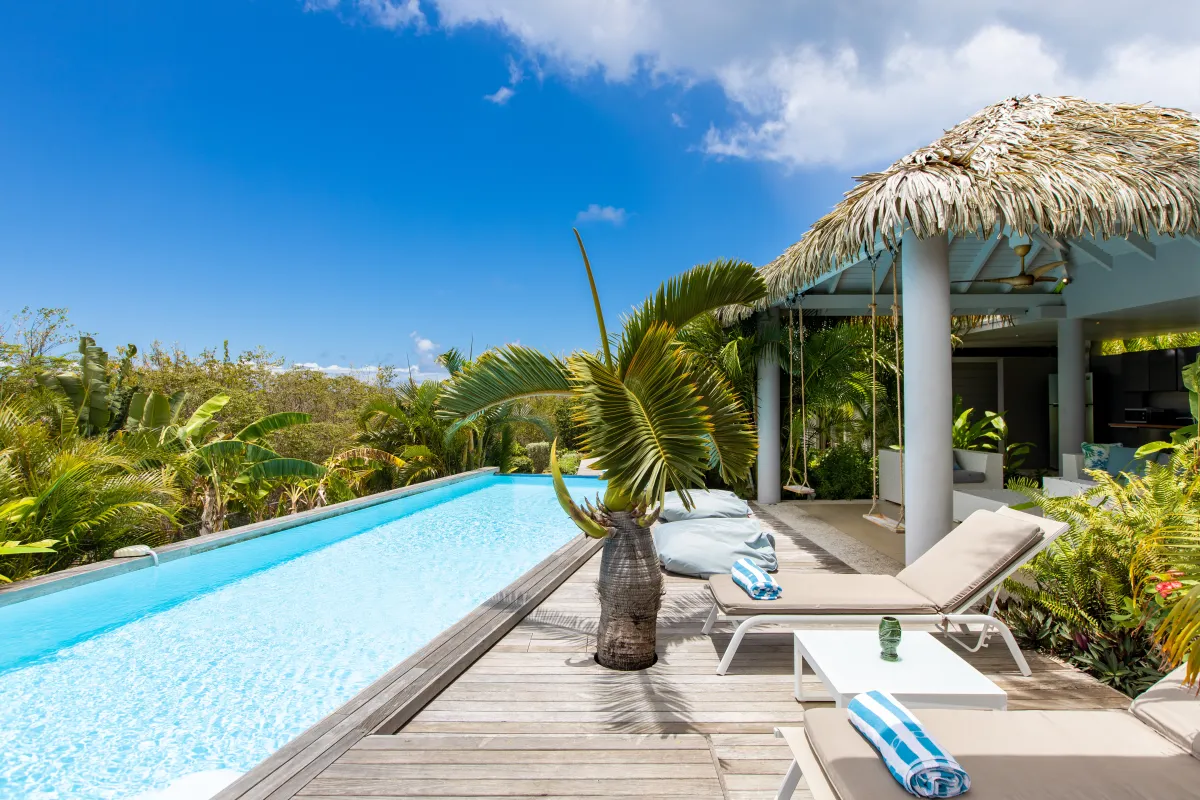 Villa Bahia Blue: Long lap pool beside a wooden sun deck with loungers and a thatched gazebo