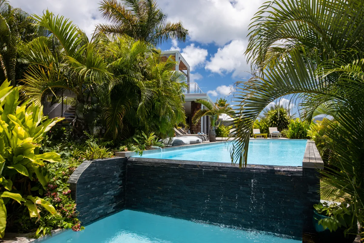 Villa Bahia Blue: Two-level swimming pool with a stone waterfall feature surrounded by tropical palm trees