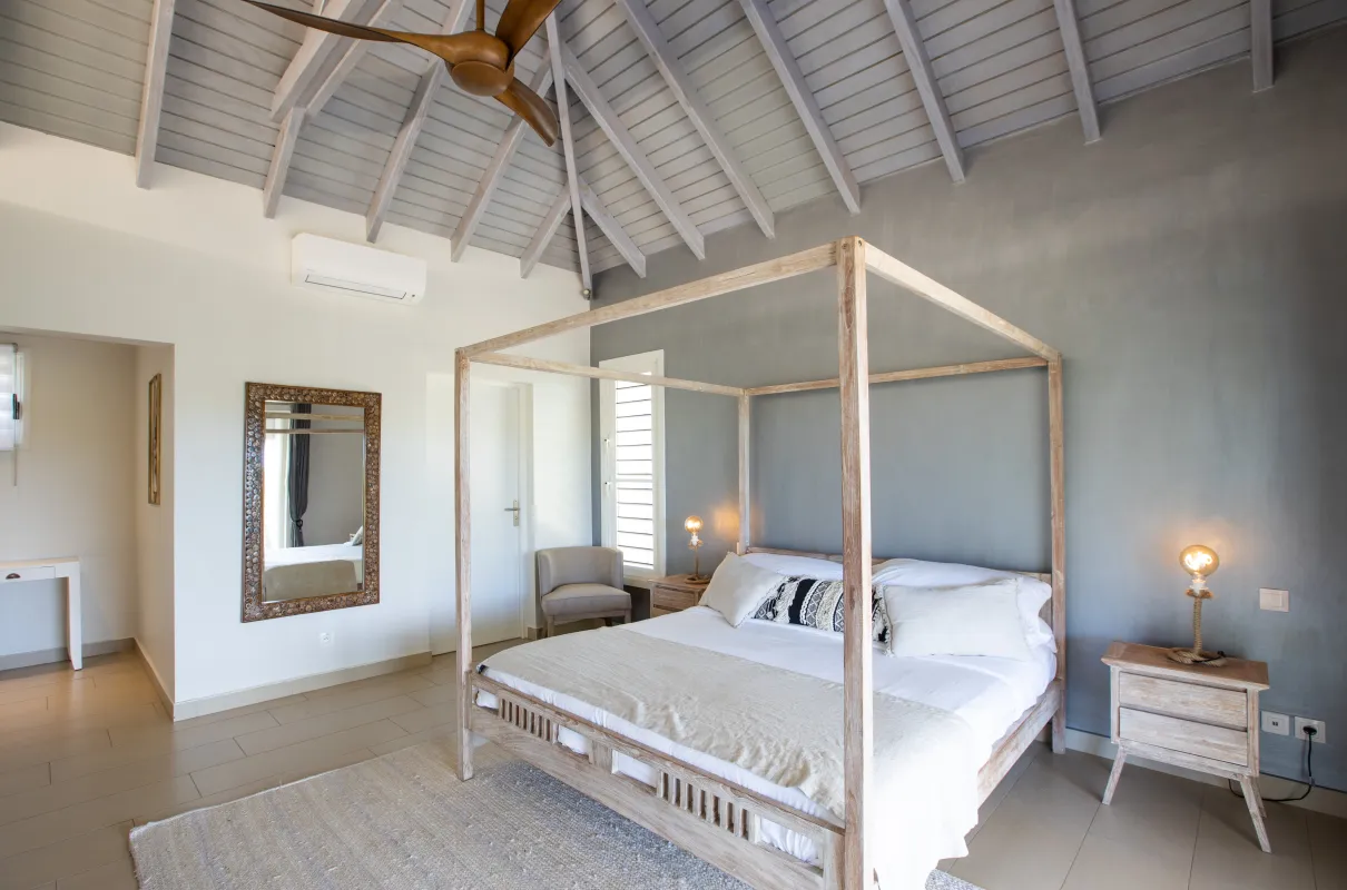 Villa Bahia Blue: Bedroom with a wooden canopy bed, vaulted ceiling, and rustic nightstands