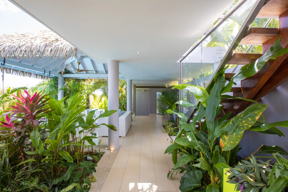 Villa Bahia Blue: Covered outdoor walkway lined with lush tropical plants and open wooden stairs