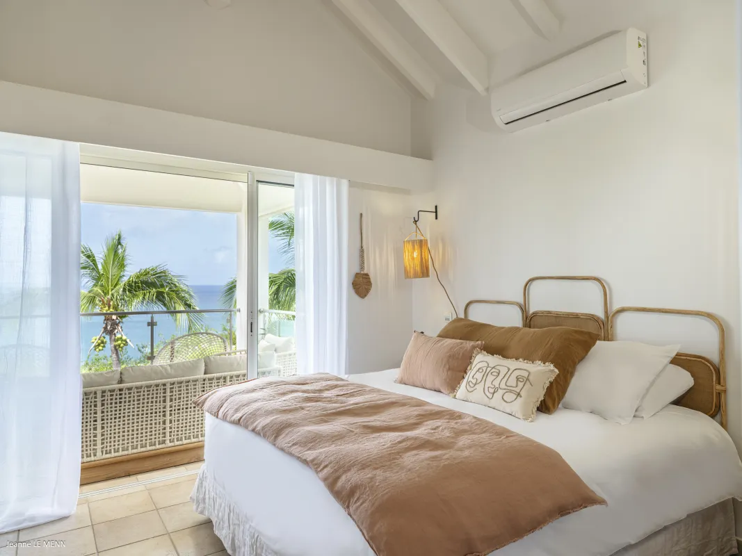Villa Be Happy: Bedroom with woven headboard and sliding doors opening to a balcony with sea views