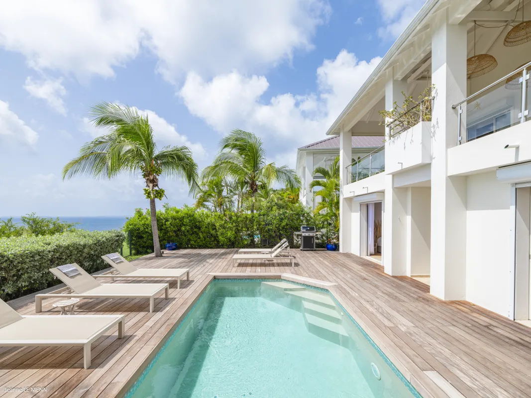 Villa Be Happy: Swimming pool and wooden deck with sun loungers outside a modern white villa