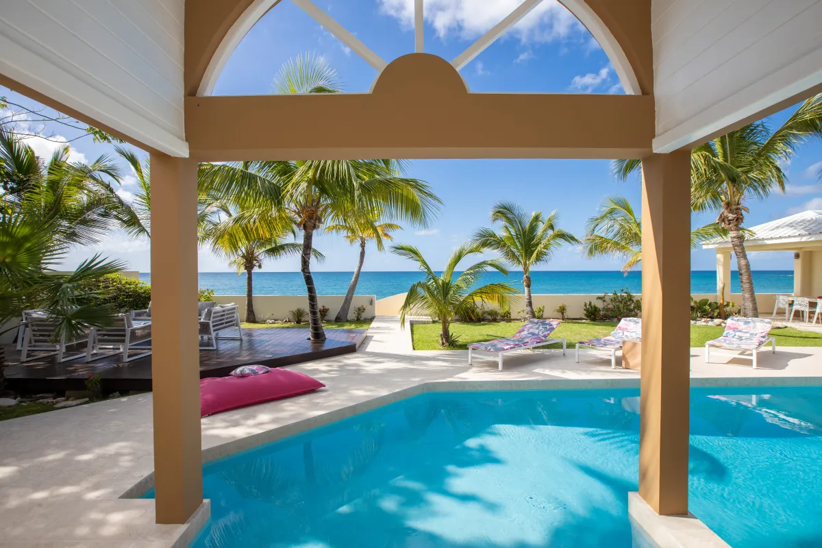 Villa Beach Secrets: Swimming pool and sun loungers framed by covered terrace overlooking the ocean