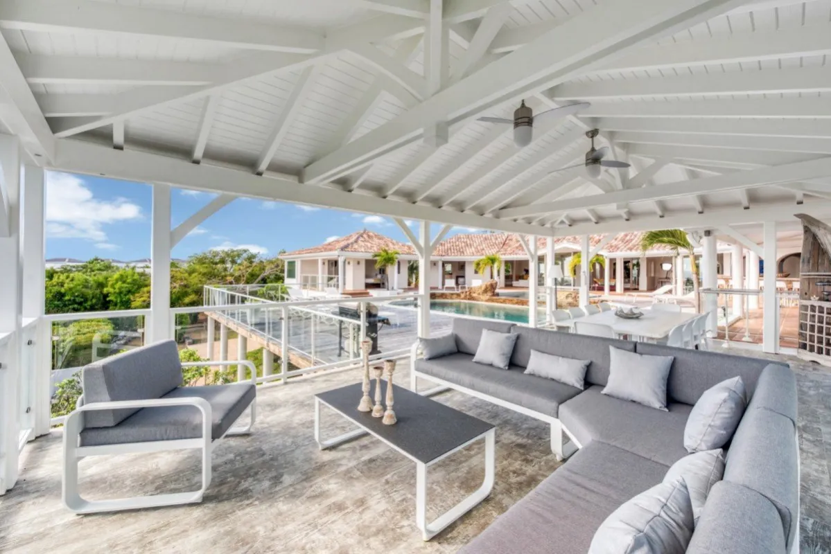 Villa Belle Fontaine: Covered terrace with gray sectional sofa overlooking the swimming pool and sun deck