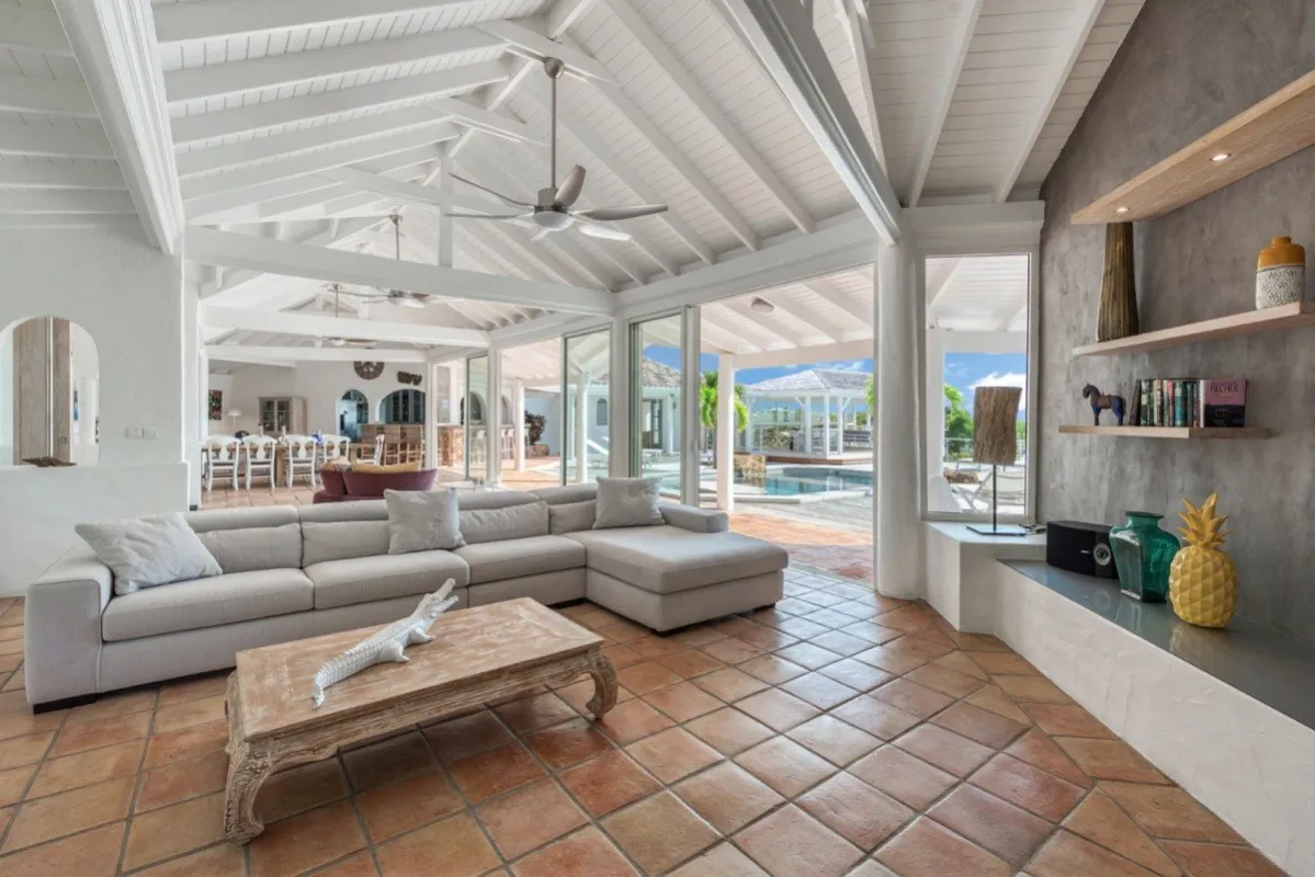 Villa Belle Fontaine: Living room with vaulted wood ceiling, sectional sofa, and doors opening to the pool patio