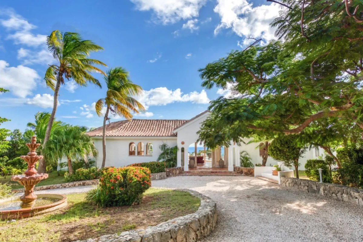 Villa Belle Fontaine: Gravel driveway leading to a white villa entrance with a tiered fountain and palm trees